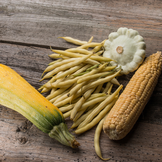 corn, squash, and beans on a table