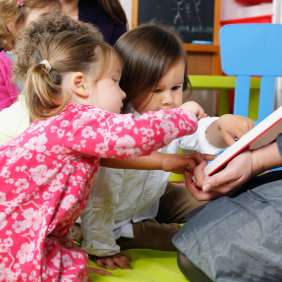 Kids sitting and touching a book